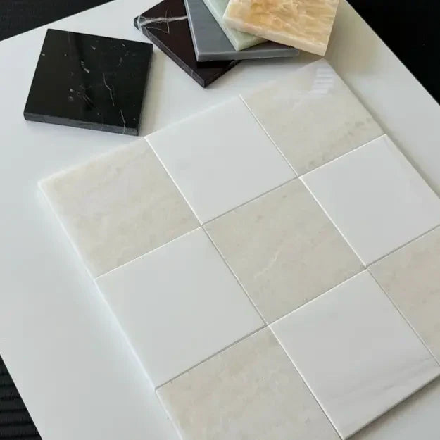 Close-up of checkerboard marble tiles in various colors on a white surface