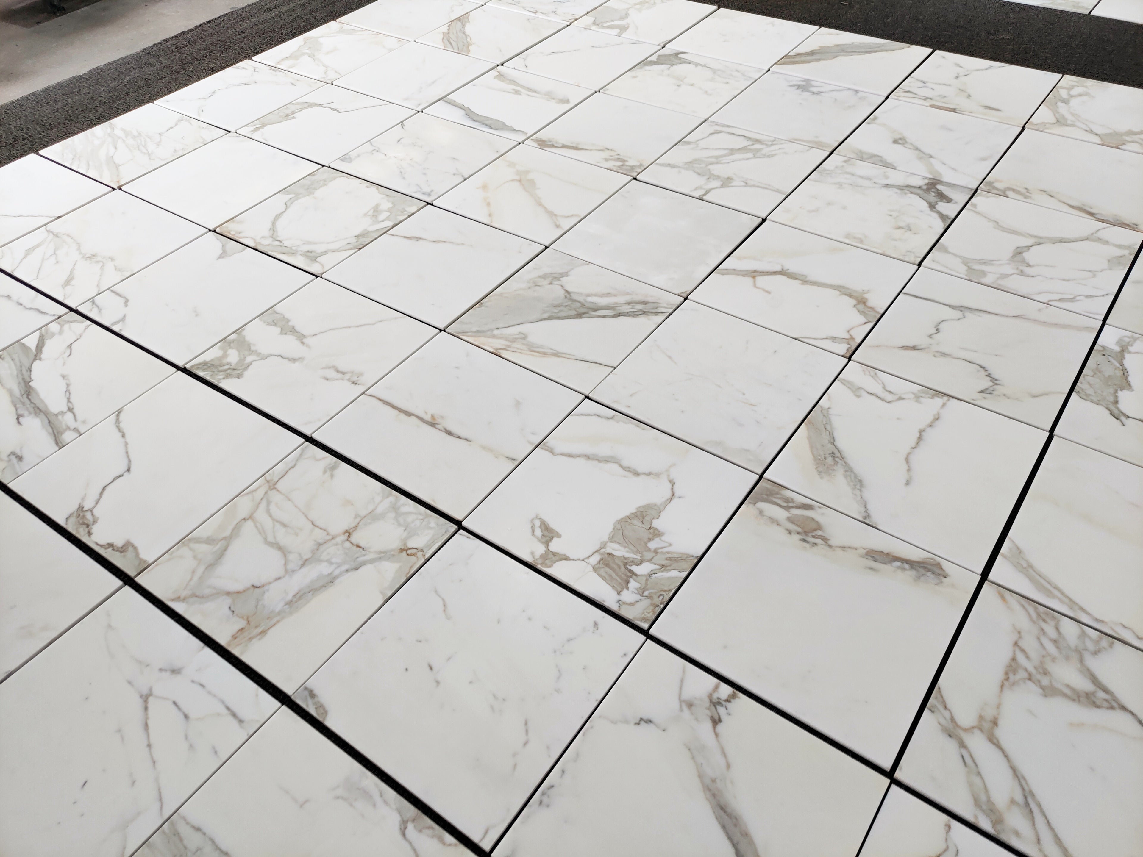 Aria calacatta gold 18x18 Marble-patterned tiles on a floor