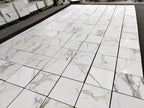 Italian Luxury Calacatta Gold Marble for high-end designers and luxury floors-patterned tiles laid out on a floor 