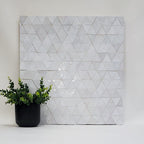 Geometric triangle patterned zellige wall art with a potted plant on a white background. (Heritage Collection)