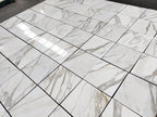 Italian Calacatta Gold marble tile 18x18 polished, dry layout showing veining variation across multiple tiles.