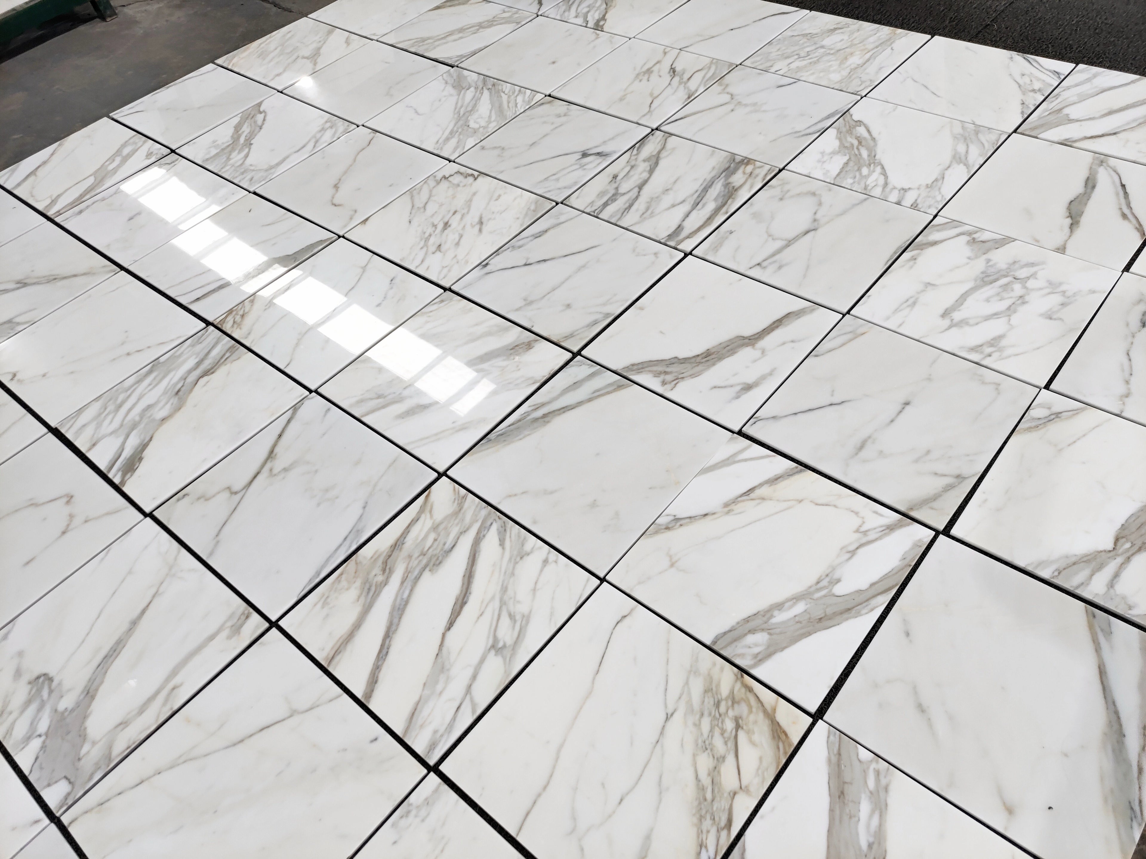Italian Calacatta Gold marble tile 18x18 polished, dry layout showing veining variation across multiple tiles.