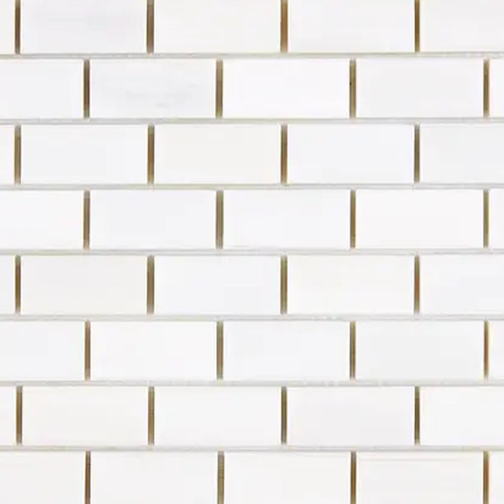 Close-up of Bianco Dolomite 1x2 brick marble mosaic showing tile edges, spacing, and natural stone variation across pieces.