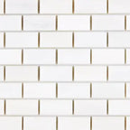 Close-up of Bianco Dolomite 1x2 brick marble mosaic showing tile edges, spacing, and natural stone variation across pieces.