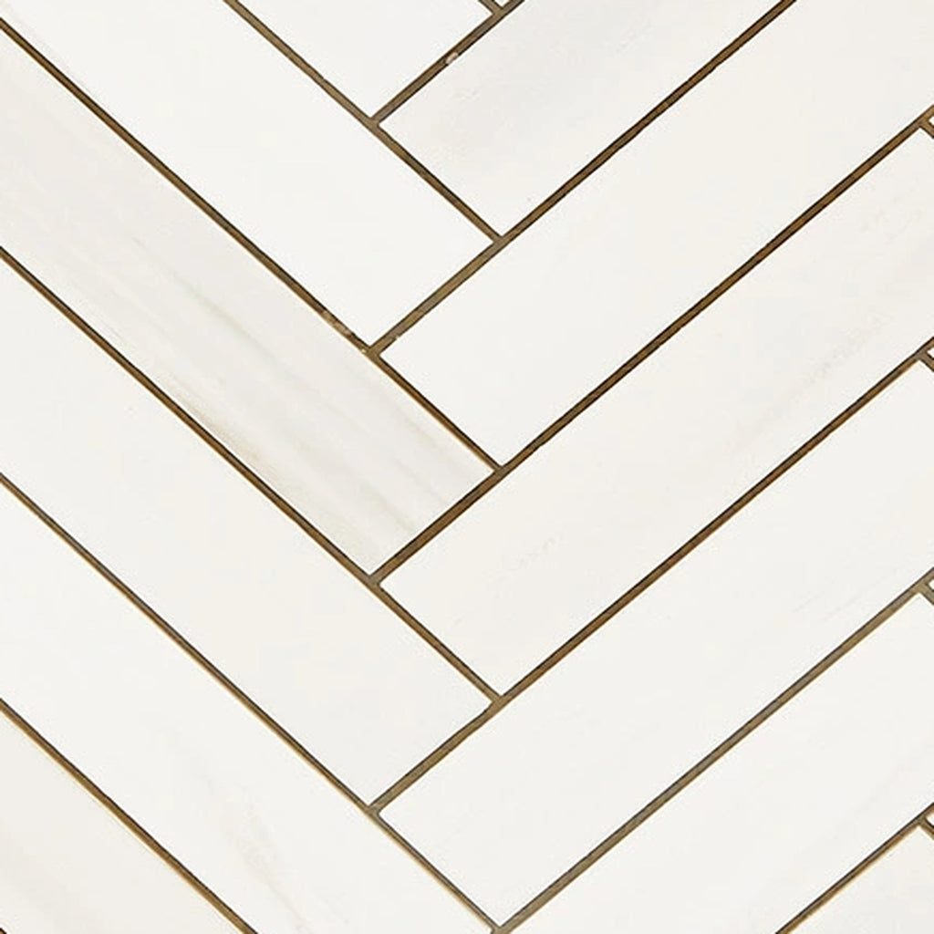 Close-up of Bianco Dolomite 1x4 herringbone marble mosaic showing tile edges, spacing, and natural stone variation.