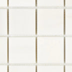 Close-up of Bianco Dolomite 2x2 marble mosaic showing tile edges, grout spacing, and natural stone variation.