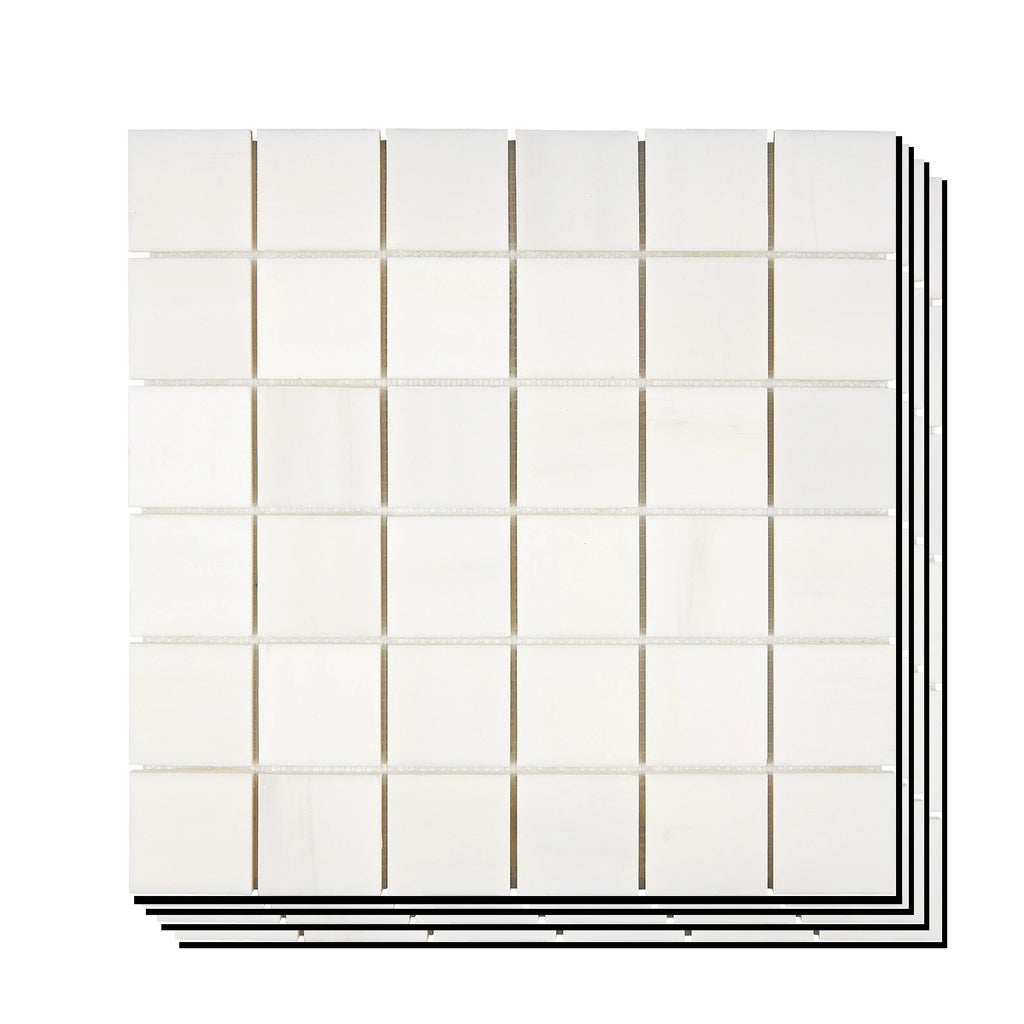 Stacked Aria Bianco Dolomite 2x2 marble mosaic sheets showing consistent color range and natural variation across pieces.