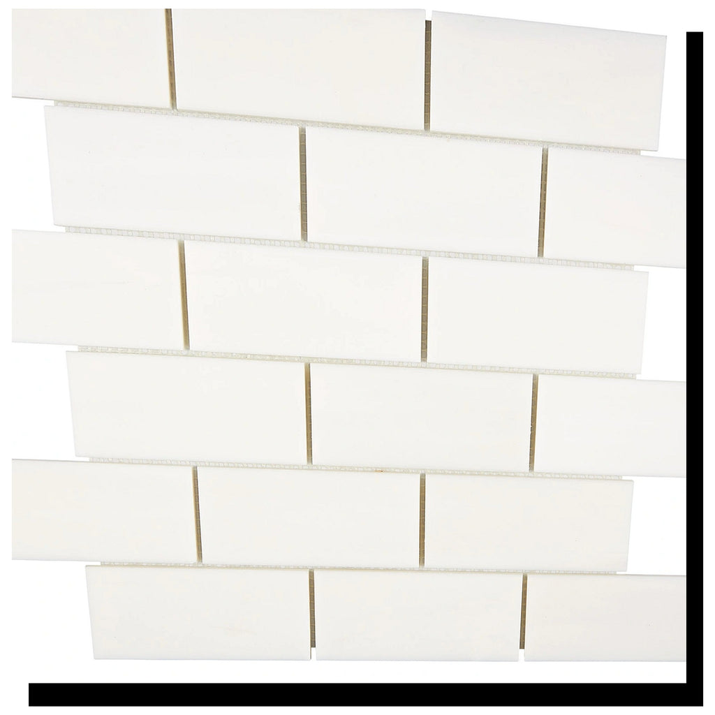 Angled view of Aria Bianco Dolomite 2x4 brick marble mosaic sheet highlighting the pattern and soft natural veining.