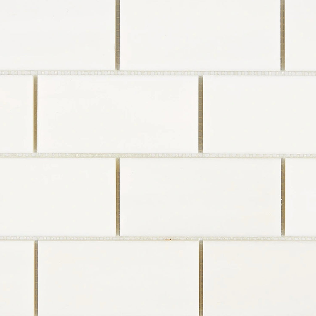 Close-up of Bianco Dolomite 2x4 brick marble mosaic showing tile edges, spacing, and natural stone variation across pieces.