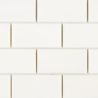 Close-up of Bianco Dolomite 2x4 brick marble mosaic showing tile edges, spacing, and natural stone variation across pieces.