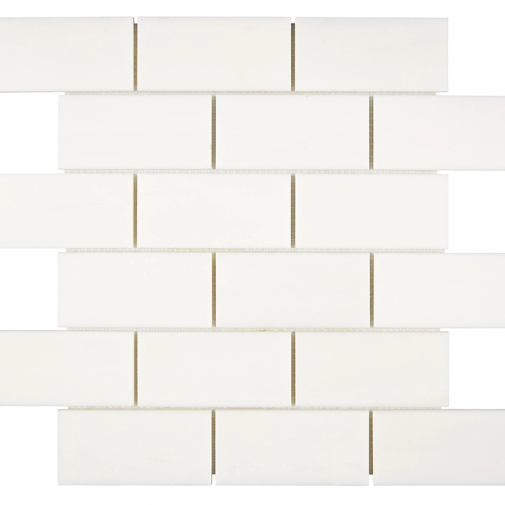 Aria Bianco Dolomite marble mosaic 2x4 brick, square studio image of a mounted sheet with subtle veining and soft tone variation.