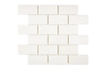 Aria Bianco Dolomite marble mosaic 2x4 brick, studio image of a mounted sheet showing subtle natural veining and soft tone variation.
