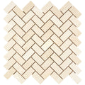 Aria Crema Marfil marble 1x2 herringbone mosaic sheet, studio image showing warm beige tones with gentle movement and natural variation in a classic herringbone pattern.