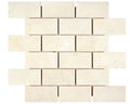 Aria Crema Marfil marble 2x4 brick mosaic sheet, studio image showing warm beige tones with gentle movement and natural variation across the mounted pattern.