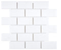 Aria Thassos White marble 2x4 subway mosaic sheet, studio image showing crisp bright-white pieces with minimal movement in a clean brick layout for shower floors, niches, and accents.