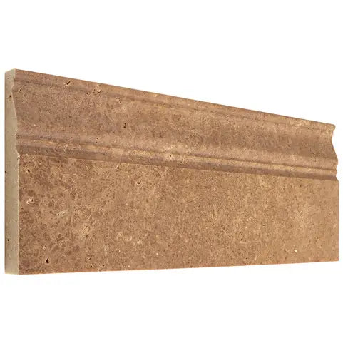 Forum Terra Umber travertine baseboard trim, studio image showing a molded rich brown profile with natural pores and subtle variation for grounded wall-to-floor transitions.