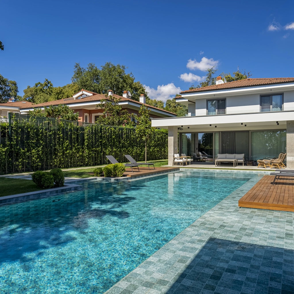 Modern pool patio with Relax porcelain pool tile and gray poolside pavers in daylight