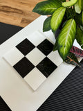 Checkered tile with a plant on a textured surface