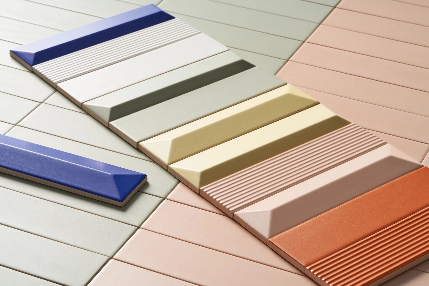Color swatches of ceramic tiles in various colors on a wooden surface