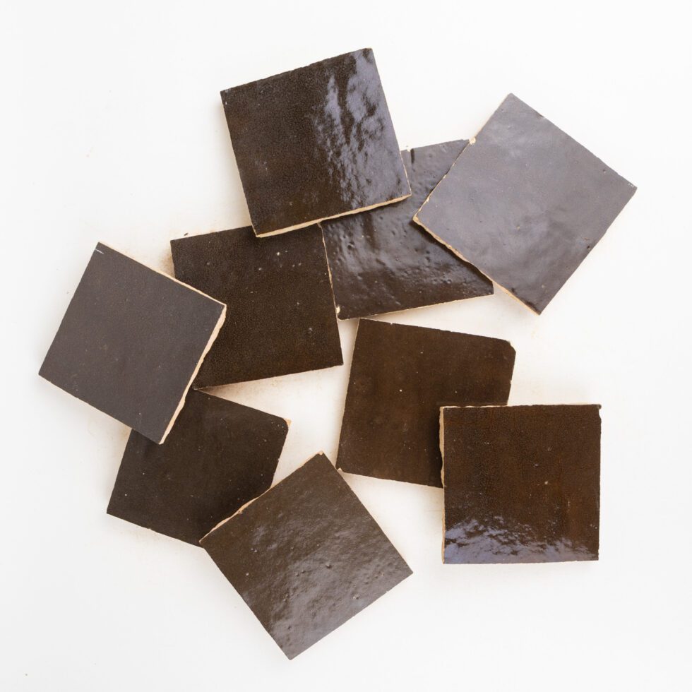 Close-up of Noir Cacao glossy zellige glaze with light-catching sheen, tonal shifts, and handmade surface texture