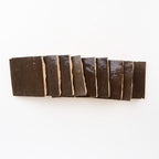 Stacked Noir Cacao 4x4 glossy zellige tiles showing hand-cut edges and natural thickness variation