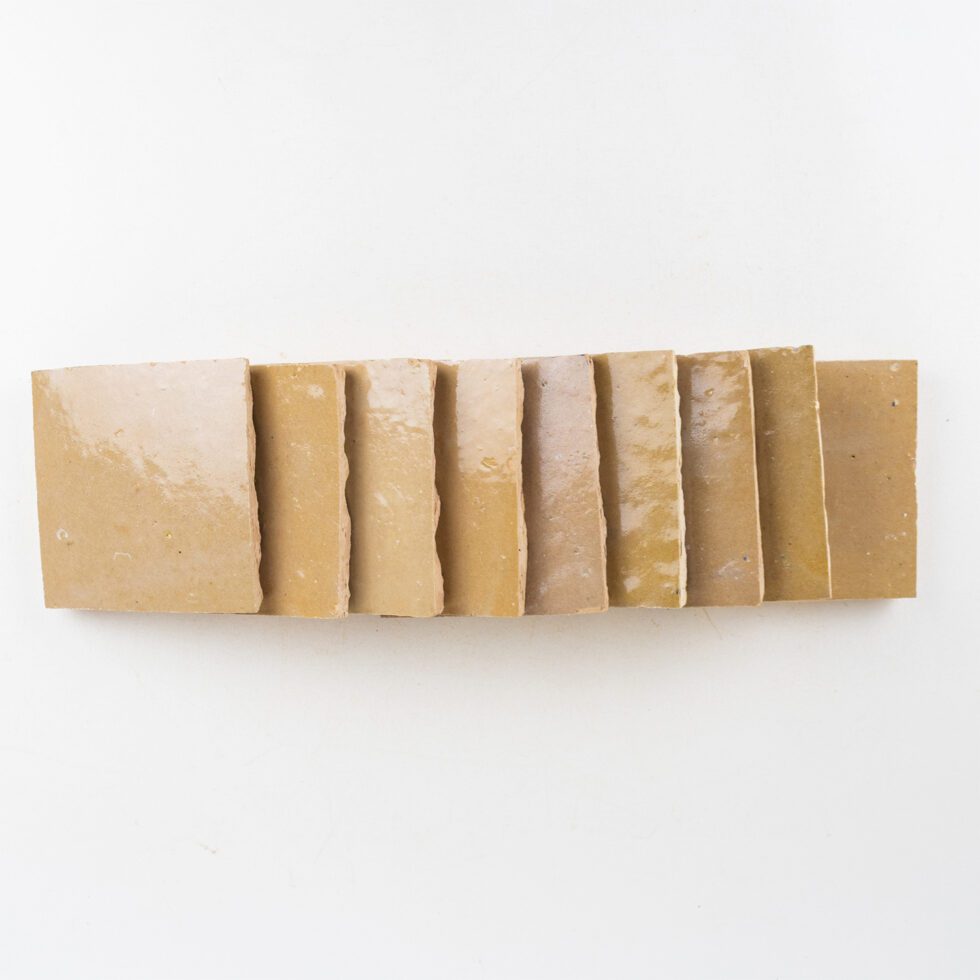Nomad Veil zellige 4x4 tile, glossy sand-beige, stacked sample tiles showing handmade edges