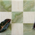 Square tiles with green and beige marble patterns and a leaf on a white background
