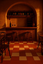 Rustic bar interior with terracotta and sand checkerboard porcelain tile floor in a matte plaster-look finish.